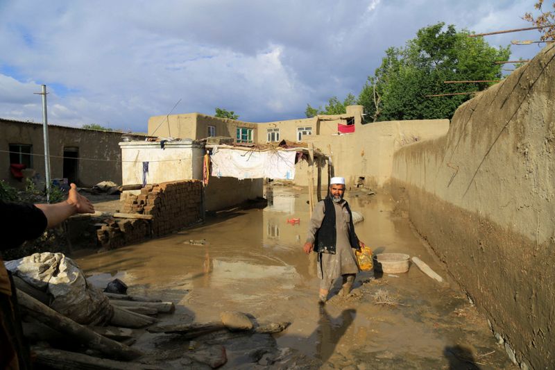 &copy; Reuters. Un hombre afgano limpia su casa dañada después de una fuerte inundación en el distrito Khushi de Logar, Afganistán. 21 de agosto, 2022. REUTERS/Stringer