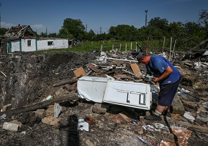 © Reuters. A local resident picks up food from the fridge near his house, destroyed by yesterday's Russian military strike, as Russia's attack on Ukraine continues, in Chaplyne, Dnipropetrovsk region, Ukraine August 25, 2022.  REUTERS/Dmytro Smolienko