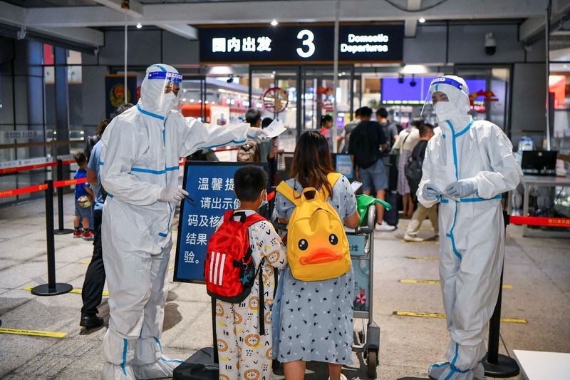 &copy; Reuters. FILE PHOTO: Tourists who were stranded amid the new outbreak of the coronavirus disease (COVID-19) arrive at the departure hall of Haikou Meilan International Airport in Haikou, Hainan province, China August 11, 2022. cnsphoto via REUTERS   