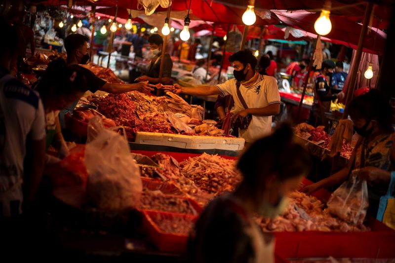 &copy; Reuters. FILE PHOTO: People wearing face masks shop inside a market amid the spread of the coronavirus disease (COVID-19) in Bangkok, Thailand, November 16, 2021. REUTERS/Athit Perawongmetha