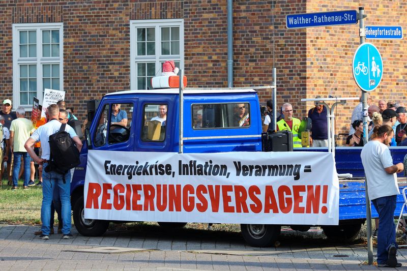 &copy; Reuters. A banner reading "energy crisis, inflation, impoverishment = government failure" is put on a vehicle as people protest while German Chancellor Olaf Scholz visits a research laboratory at Magdeburg University, in Magdeburg, Germany, August 25, 2022. REUTER