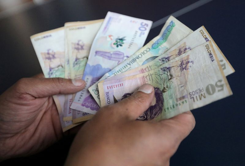 &copy; Reuters. Foto de archivo de un empleado con billetes de pesos colombianos en una tienda en Bogota
Dic 28, 2018. REUTERS/Luisa Gonzalez/ 
