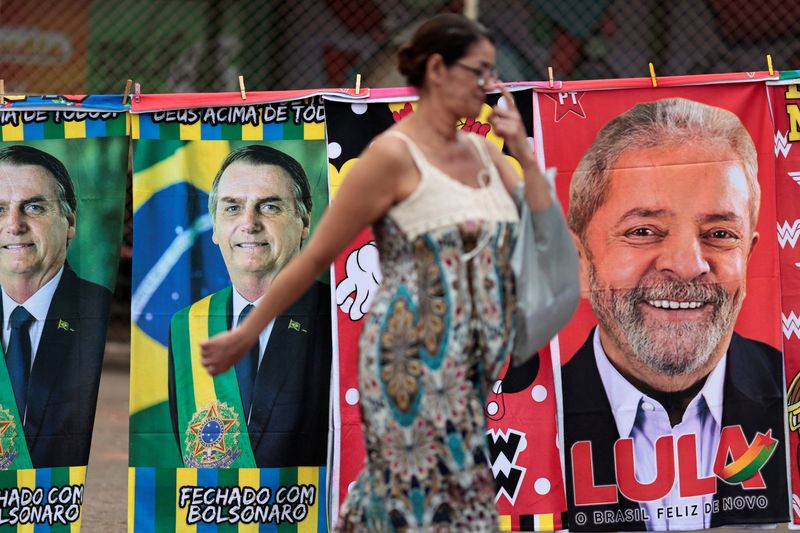 &copy; Reuters. Mulher passa por camelô vendendo toalhas do ex-presidente Lula e do presidente Jair Bolsonaro
16/08/2022
REUTERS/Ueslei Marcelino