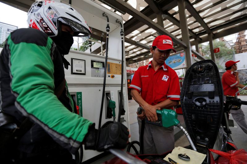 &copy; Reuters. FILE PHOTO: An employee at a Total fuel station fills up a motorcycle in south Jakarta February 12, 2015. Picture taken February 12, 2015. REUTERS/Darren Whiteside/File Photo