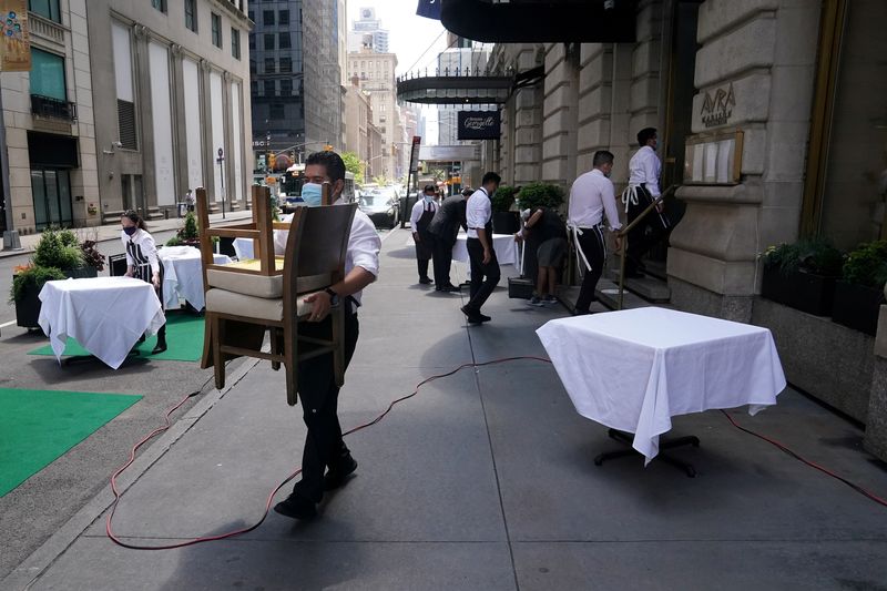 &copy; Reuters. FILE PHOTO: A waiter sets up tables in front of a restaurant on a street on the first day of the phase two re-opening of businesses following the outbreak of the coronavirus disease (COVID-19), in the Manhattan borough of New York City, New York, U.S., Ju