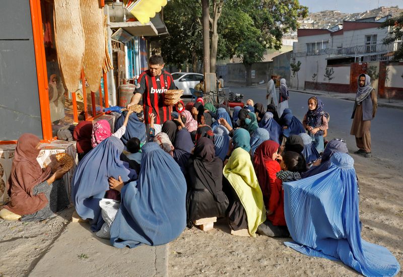 &copy; Reuters. An Afghan girl receives a loaf of bread in front of a bakery among the crowd in Kabul, Afghanistan, August 5, 2022. REUTERS/Ali Khara
