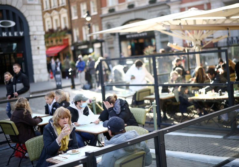 &copy; Reuters. FILE PHOTO: People sit at an outside restaurant area, as the coronavirus disease (COVID-19) restrictions ease, at Covent Garden in London, Britain April 12, 2021. REUTERS/Henry Nicholls