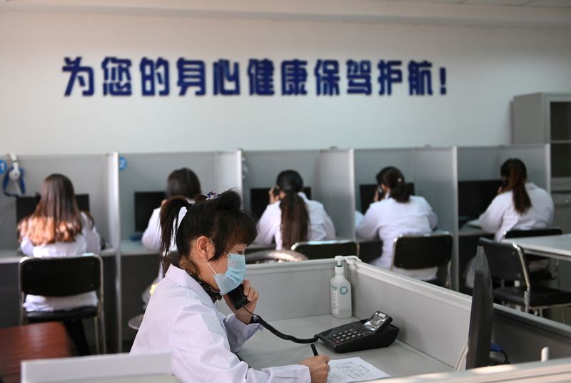 &copy; Reuters. FILE PHOTO: A hotline operator for a free counselling service answers a phone while wearing a face mask, as the country is hit by an outbreak of the novel coronavirus, in Shenyang, Liaoning province, China February 12, 2020. cnsphoto via REUTERS