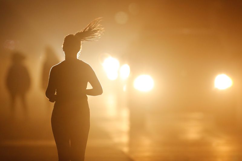&copy; Reuters. FILE PHOTO: A women jogs along a roadside as temperatures cool off after sunset in Oceanside, California, U.S. July 5, 2018.        REUTERS/Mike Blake