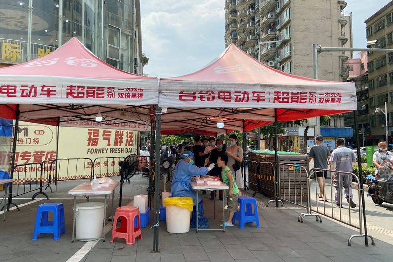 &copy; Reuters. Un travailleur médical prélève un écouvillon sur un résident dans un site de test d'acide nucléique à Shenzhen, dans la province de Guangdong, en Chine. De grandes villes chinoises ont instauré mardi pour plusieurs jours de nouvelles restrictions 