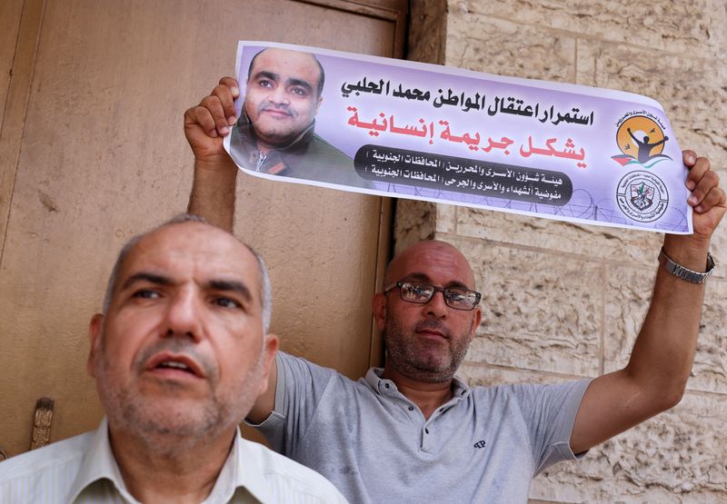 &copy; Reuters. رجل يحمل صورة محمد الحلبي خلال تجمع للتضامن معه في أمام مكتب اللجنة الدولية للصليب الأحمر في مدينة غزة يوم الثلاثاء. تصوير: محمد سالم - رويتر