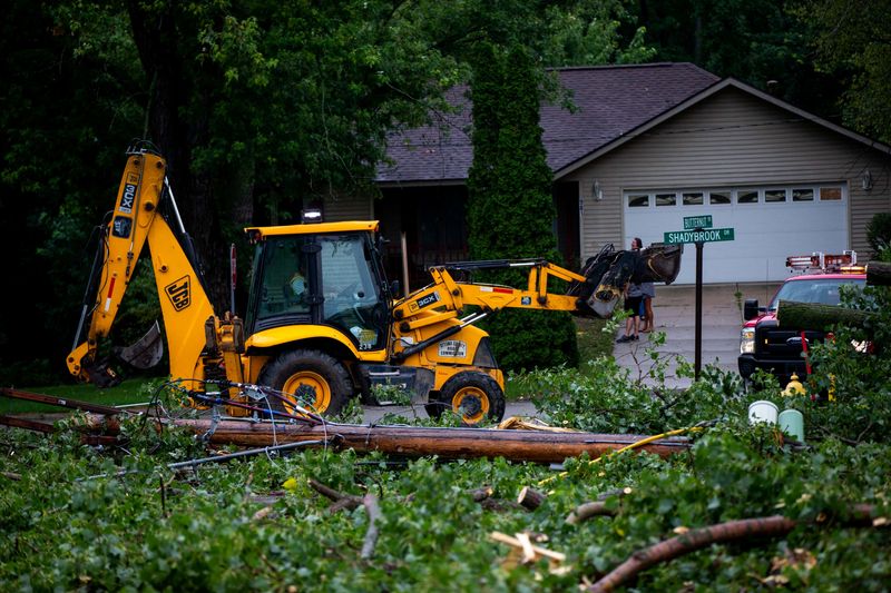 © Reuters. Fallen tree limbs are cleared after thunderstorms and high winds downed power lines and closed roads in Holland, Michigan, U.S. August 29, 2022.  Cody Scanlan/USA Today Network via REUTERS