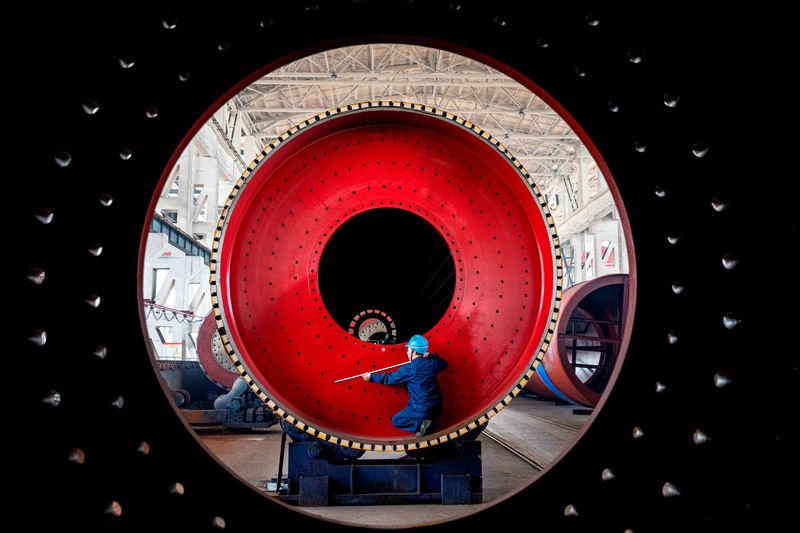 &copy; Reuters. FILE PHOTO: An employee measures a newly manufactured ball mill machine at a factory in Nantong, Jiangsu province, China June 28, 2019. Picture taken through a ball mill machine June 28, 2019. REUTERS/Stringer 