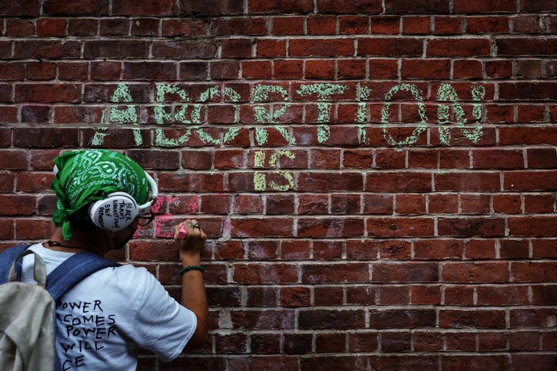 © Reuters. FILE PHOTO: An abortion rights activist writes with chalk on a wall outside of St. Patrick's Old Cathedral in New York City,  U.S., August 6, 2022. REUTERS/Shannon Stapleton