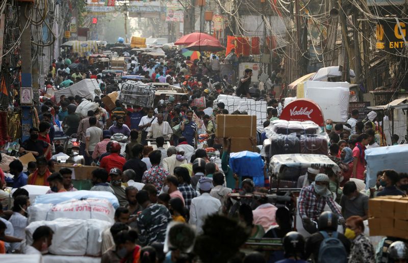 © Reuters. FILE PHOTO: People walk at a crowded market amidst the spread of the coronavirus disease (COVID-19), in the old quarters of Delhi, India, April 6, 2021. REUTERS/Anushree Fadnavis