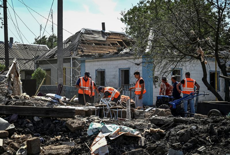 &copy; Reuters. FILE PHOTO: Communal workers clean an area around houses damaged by yesterday's Russian military strike, as Russia's attack on Ukraine continues, in Chaplyne, Dnipropetrovsk region, Ukraine August 25, 2022.  REUTERS/Dmytro Smolienko