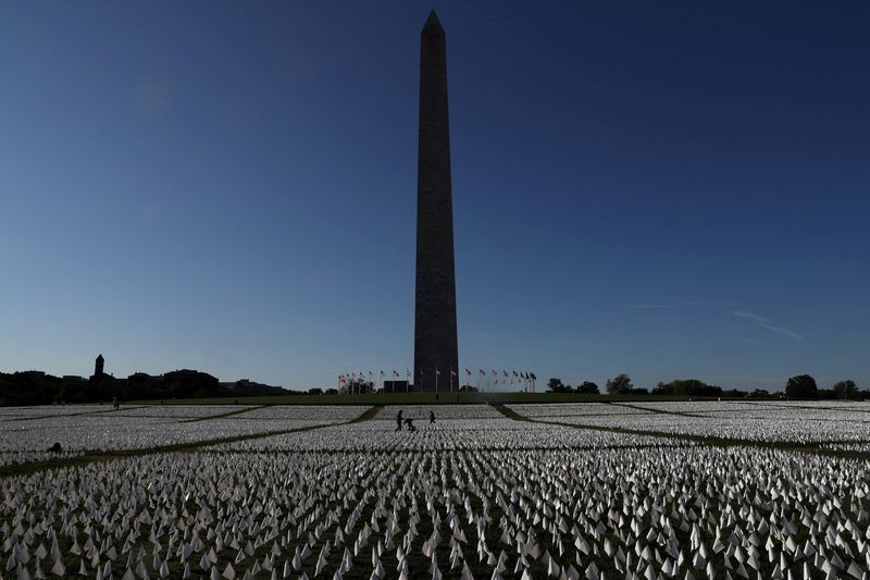 &copy; Reuters. FILE PHOTO: People visit Suzanne Brennan Firstenberg's "In America: Remember", a memorial for Americans who died due to the coronavirus disease (COVID-19) as the national death toll nears 700,000, next to the Washington Monument in Washington, U.S., Octob