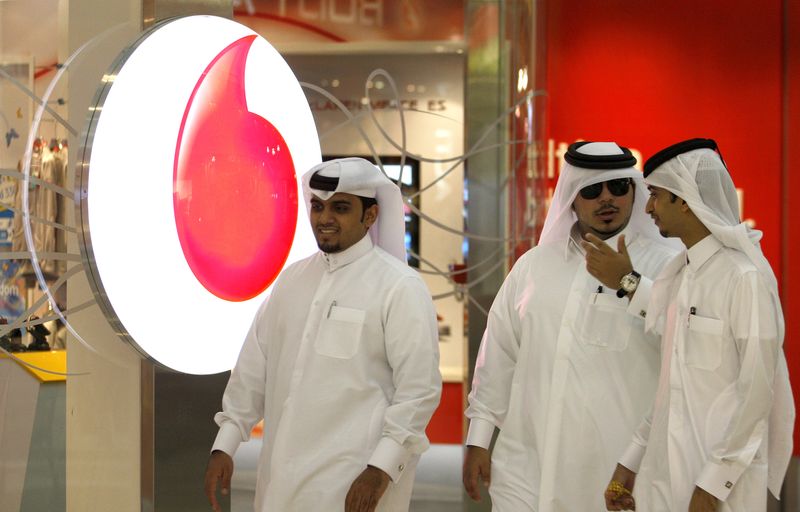 &copy; Reuters. رجال يمرون بمكتب فودافون قطر في الدوحة بصورة من أرشيف رويترز.