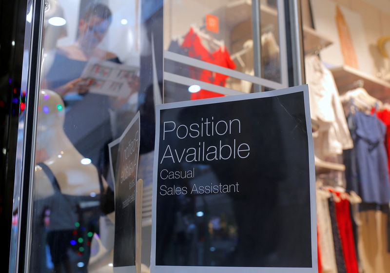 &copy; Reuters. FILE PHOTO: A sales assistant is seen through the window of a retail store displaying a job vacancy sign in central Sydney, Australia, December 5, 2016. Picture taken December 5, 2016.     REUTERS/Steven Saphore