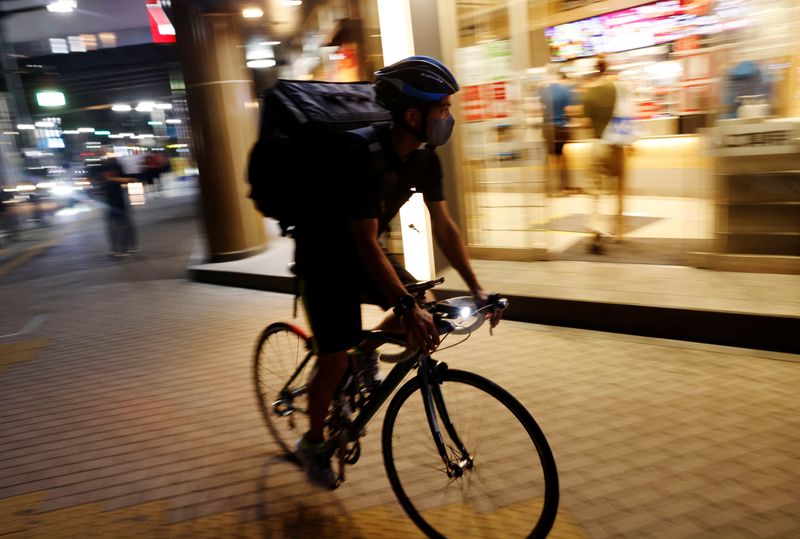 © Reuters. Riku Omori rides a bicycle to work for the food delivery service after finishing his regular job in Kawasaki, south of Tokyo, Japan August 31, 2022. REUTERS/Kim Kyung-Hoon