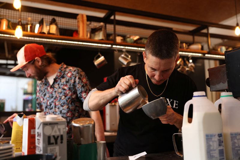 © Reuters. Barista Claudio Chimisso prepares a coffee at Bay Ten Espresso, a cafe that has struggled with filling staff job openings in recent months due to a worker shortage according to its owner, in Sydney, Australia, August 31, 2022. REUTERS/Loren Elliott