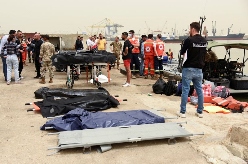 &copy; Reuters. FILE PHOTO: People stand near stretchers that are prepared for dead bodies after a boat capsized off the Lebanese coast of Tripoli overnight, at port of Tripoli, northern Lebanon April 24, 2022. REUTERS/Omar Ibrahim