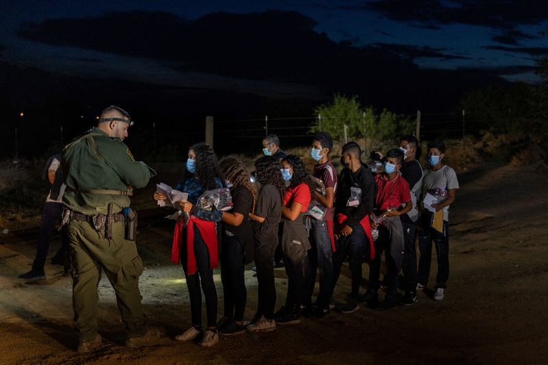 © Reuters. Youth migrants traveling without adults are processed by a border patrol agent after being smuggled across the Rio Grande river into Roma, Texas, U.S., August 26, 2022.  REUTERS/Adrees Latif
