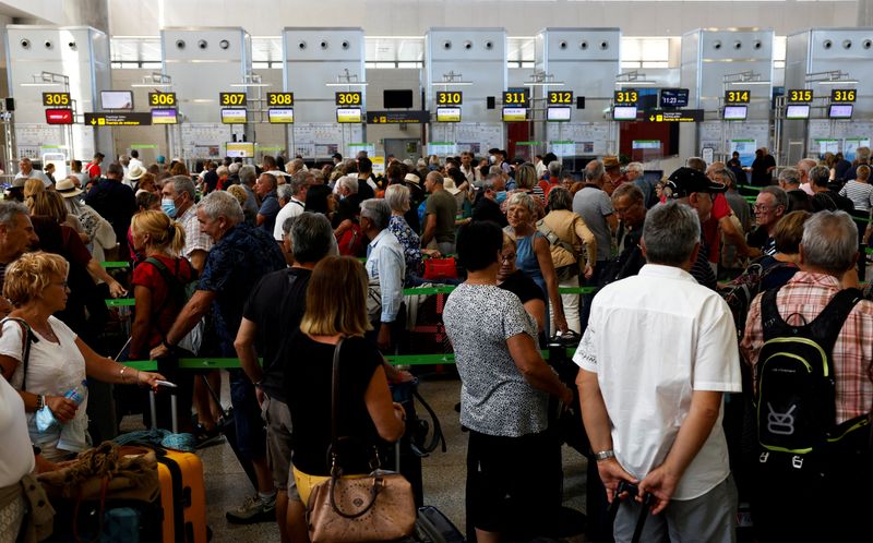 &copy; Reuters. FOTO DE ARCHIVO: Viajeros haciendo fila frente a los mostradores de facturación del aeropuerto de Málaga-Costa del Sol en Málaga, Andalucía, España, el 4 de junio de 2022. REUTERS/Jon Nazca