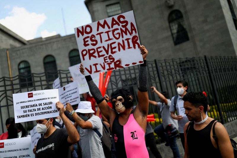 &copy; Reuters. FILE PHOTO: Activists hold signs during a protest to call for a stronger response by the government to the monkeypox crisis, outside the Health Secretary building, in Mexico City, Mexico, Mexico, July 26, 2022. The sign on the right reads: "No more stigma