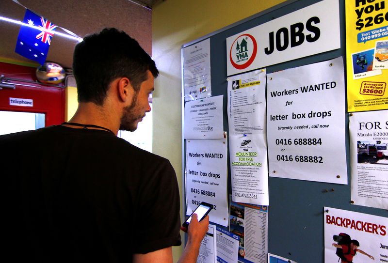 &copy; Reuters. FILE PHOTO: A man uses his phone to record a job add posted on a notice board at a backpacker hostel in Sydney, Australia, May 9, 2016. Picture taken May 9, 2016.  REUTERS/Steven Saphore