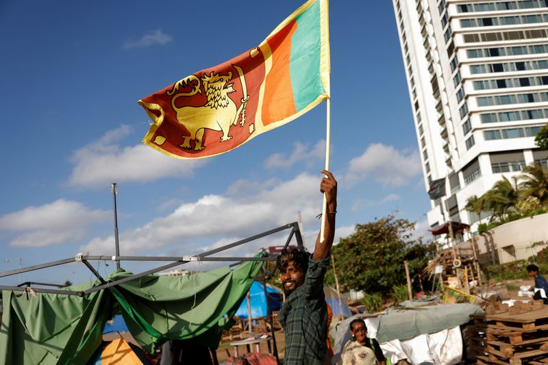 &copy; Reuters. FILE PHOTO: A protesters holds a national flag at a seafront tent camp that became the focal point of months-long nationwide demonstrations, as the deadline police asked them to leave the camp is approaching, amid the country's economic crisis, in Colombo