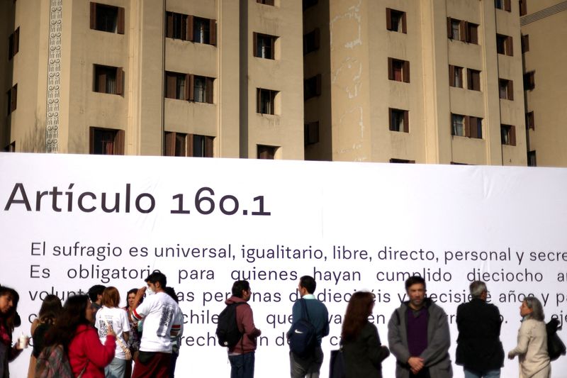 &copy; Reuters. FILE PHOTO: People stand next to a banner showing item number 160.1 of the proposed new Chilean constitution placed in a public area ahead of the September 4th constitutional referendum, in Santiago, Chile August 23, 2022. REUTERS/Ivan Alvarado/File Photo