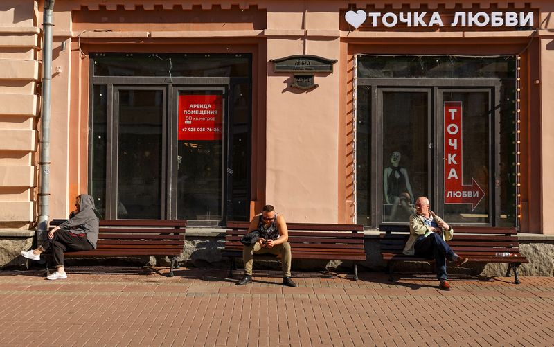 &copy; Reuters. FILE PHOTO: People rest on benches near a window of business premises put out for rent in Moscow, Russia June 8, 2022. REUTERS/Evgenia Novozhenina