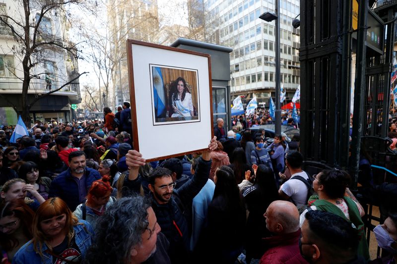 © Reuters. A man holds a picture of Argentine Vice President Cristina Fernandez during a march to protest against an incident in which a man pointed a gun at her outside her home, in Buenos Aires, Argentina September 2, 2022. REUTERS/Agustin Marcarian 
