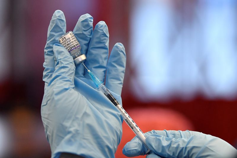&copy; Reuters. FILE PHOTO: A nurse prepares the vials of the Pfizer coronavirus disease (COVID-19) vaccine for use at a pop-up vaccination clinic in the Central Fire Station in Belfast, Northern Ireland, December 4, 2021. REUTERS/Clodagh Kilcoyne/File Photo