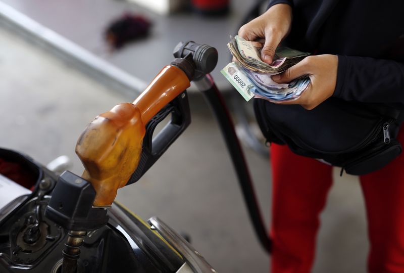 &copy; Reuters. FILE PHOTO: A worker at a state-owned Pertamina petrol station holds money as a motorcycle is filled with subsidised fuel in Jakarta October 31, 2014. REUTERS/Darren Whiteside 