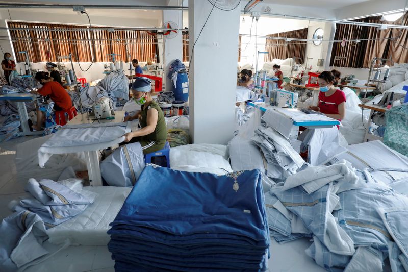 &copy; Reuters. FILE PHOTO: Labourers wear protective masks as they work at a private Ngoc Nu factory which makes blankets, pillows and mattresses for the local market after the government eased nationwide lockdown following the coronavirus disease (COVID-19) outbreak, i