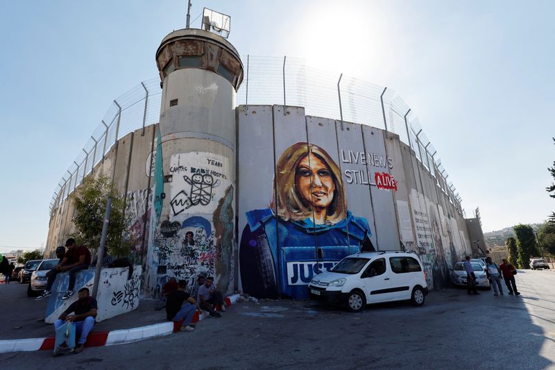 &copy; Reuters. FILE PHOTO: Palestinians sit in front of a mural depicting the slain Palestinian-American journalist Shireen Abu Akleh ahead of the visit of U.S. President Joe Biden at Bethlehem in the Israeli-occupied West Bank July 13, 2022. REUTERS\Mussa Qawasma