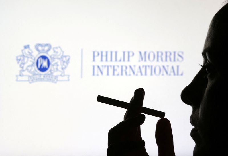 &copy; Reuters. A woman poses with a cigarette in front of Philip Morris International logo in this illustration taken July 26, 2022. REUTERS/Dado Ruvic/Illustration