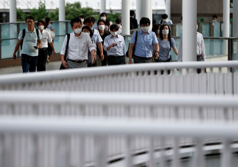 &copy; Reuters. Office workers wearing protective face masks head home during the spread of the coronavirus disease (COVID-19), at a station in Tokyo, Japan June 24, 2020.  REUTERS/Issei Kato