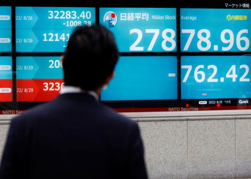 &copy; Reuters. رجل ينظر إلى شاشة إلكترونية تظهر حركة تداول الأسهم على مؤشر نيكي القياسي ببورصة طوكيو في 29 أغسطس آب 2022. تصوير : كيم كيونغ-هون- رويترز .  