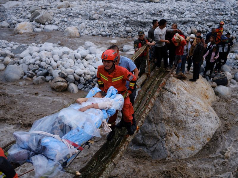 &copy; Reuters. Rescue workers carry an injured victim on a stretcher following a 6.8-magnitude earthquake in Qinggangping village, Luding county, Ganzi Tibetan Autonomous Prefecture, Sichuan province, China September 5, 2022. China Daily via REUTERS
