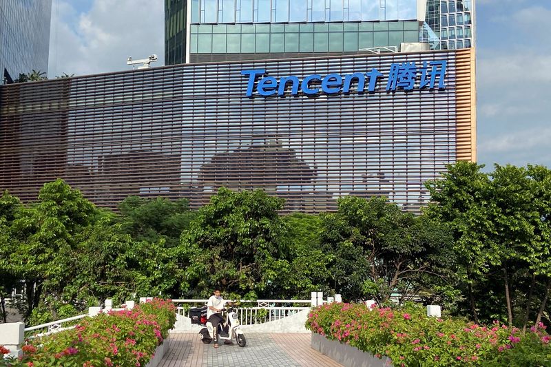 &copy; Reuters. FILE PHOTO: A man rides an electric bike past the Tencent headquarters in Nanshan district of Shenzhen, Guangdong province, China September 2, 2022. REUTERS/David Kirton