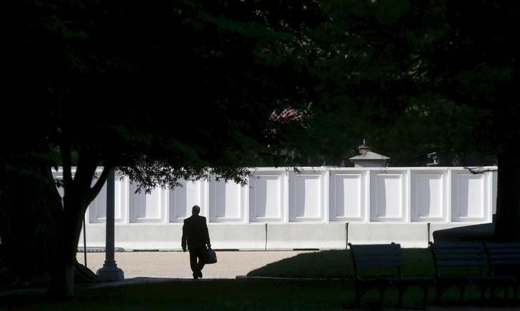 © Reuters. A man carrying a briefcase makes his way through Lafayette Park near the White House in Washington June 24, 2015.  REUTERS/Kevin Lamarque 