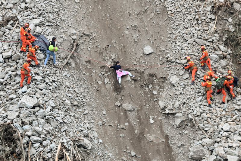 © Reuters. Rescue workers evacuate quake-affected residents at the site of a landslide near Moxi town, following a 6.8-magnitude earthquake in Luding county, Ganzi Tibetan Autonomous Prefecture, Sichuan province, China September 6, 2022. China Daily via REUTERS  