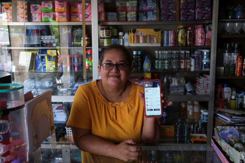 &copy; Reuters. Gloria Barcia shows her Bitcoin wallet at her store in the town of Conchagua, near the projected site for the Bitcoin City according to El Salvador's President Nayib Bukele, in Conchagua, El Salvador August 19, 2022. REUTERS/Jose Cabezas
