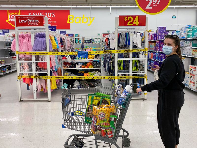 &copy; Reuters. FILE PHOTO: A woman looks on as she walks past cordoned off aisles of non-essential goods at a Walmart store in Toronto, Ontario, Canada April 8, 2021. REUTERS/Carlos Osorio