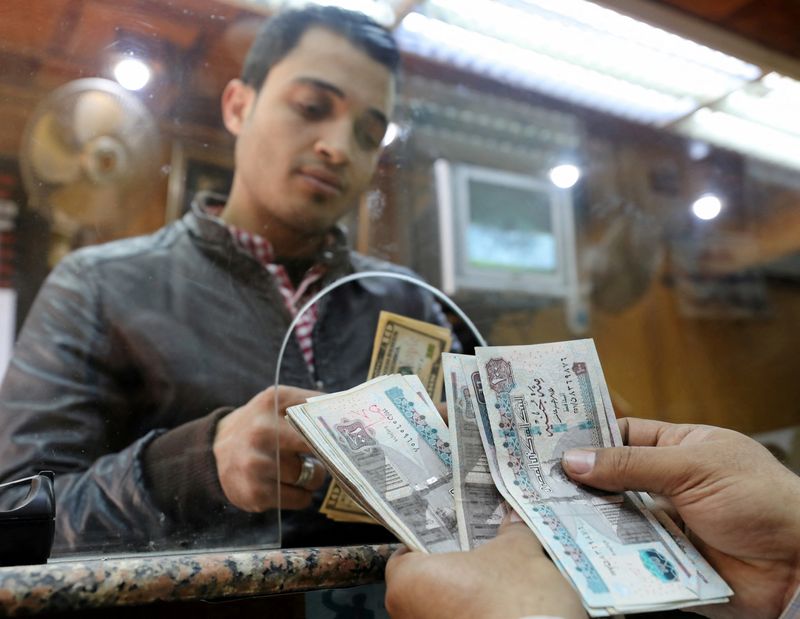 &copy; Reuters. أحد الزبائن لدى صرافة يستبدل دولارات بجنيهات مصرية في صورة من أرشيف رويترز.