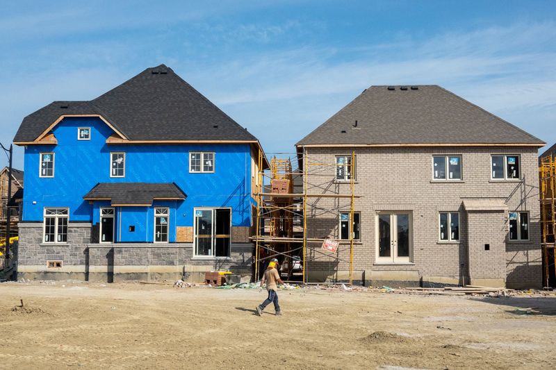 &copy; Reuters. FILE PHOTO: A construction crew walks in front of new homes under construction, on the day Bank of Canada increased its policy rate a full percentage point in Brampton, Ontario, Canada July 13, 2022. REUTERS/Carlos Osorio