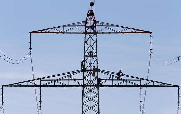 &copy; Reuters. 　ドイツ政府は、電力使用料の負担軽減策をまとめた。一般家庭向けには基本的な使用部分の負担を助成し、中小企業向けにより安価な電力を確保する。写真はミュンヘン近郊の送電塔。２